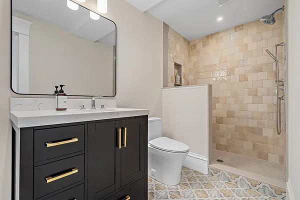a bathroom with a sink a toilet and shower