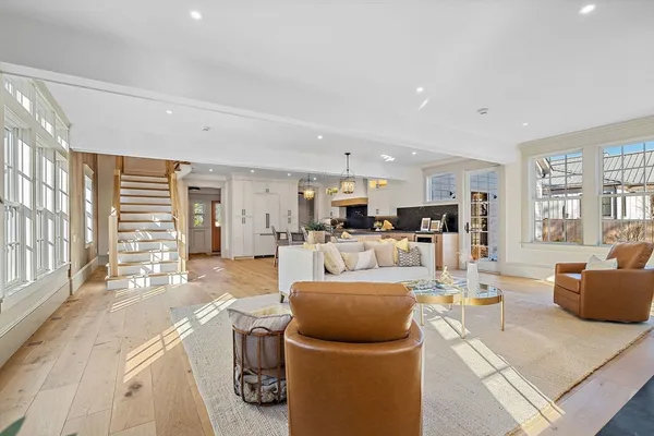 a living room with furniture a large window and kitchen view