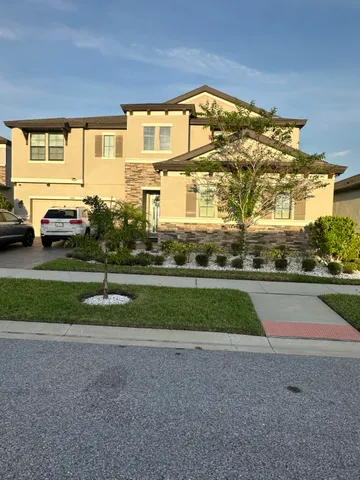 a front view of a house with a garden and parking space