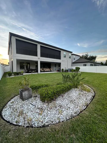 a view of a yard with a table and chairs under an umbrella