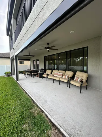 a view of a swimming pool with a patio and a yard