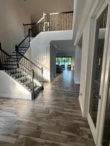 a dining room with wooden floor a chandelier a glass table and chairs