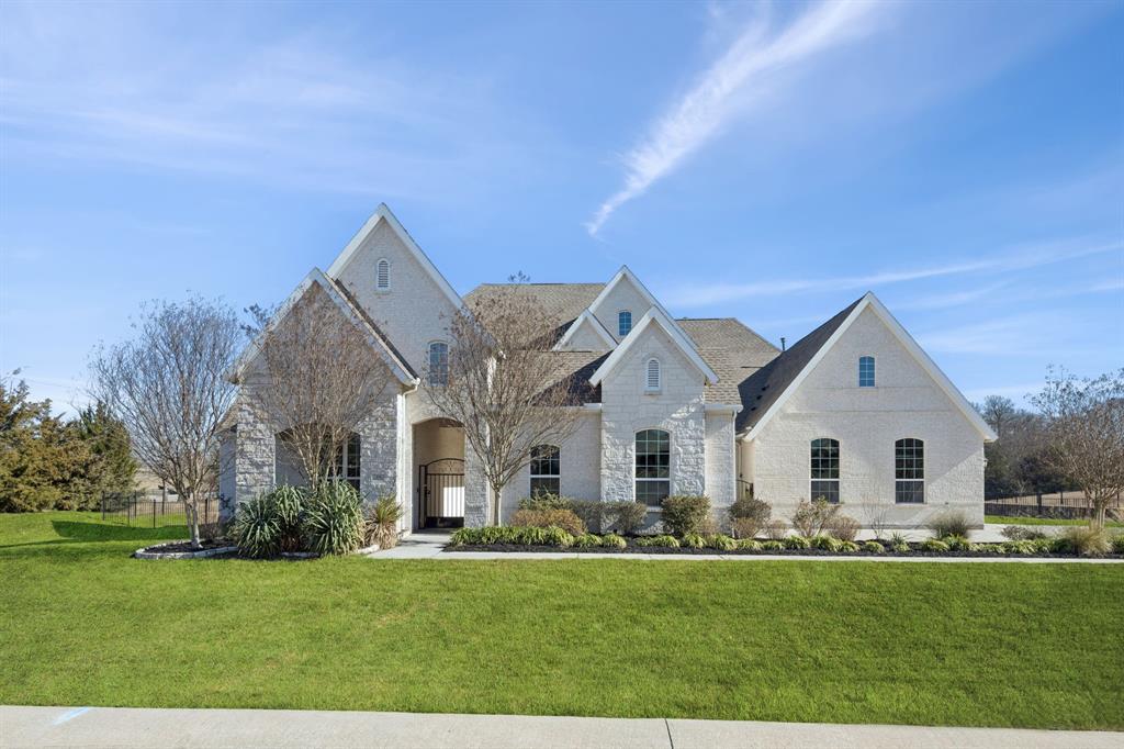 a view of a white house with a big yard and potted plants