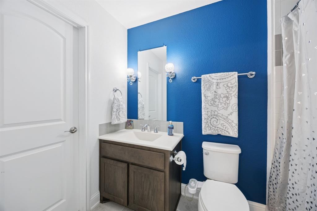 330 Bonham Boulevard Fairview, TX 75069 - Photo 23 of 32 a bathroom with a toilet sink vanity and mirror