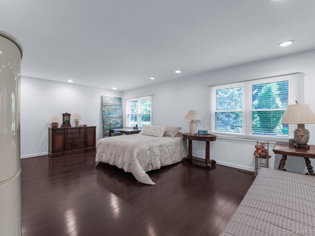 15 Fairway Circle South, Unit 15 Manhasset, NY 11030 - Photo 19 of 39 First Floor Primary Bedroom with dark wood-type flooring, recessed lighting, and freestanding refrigerator