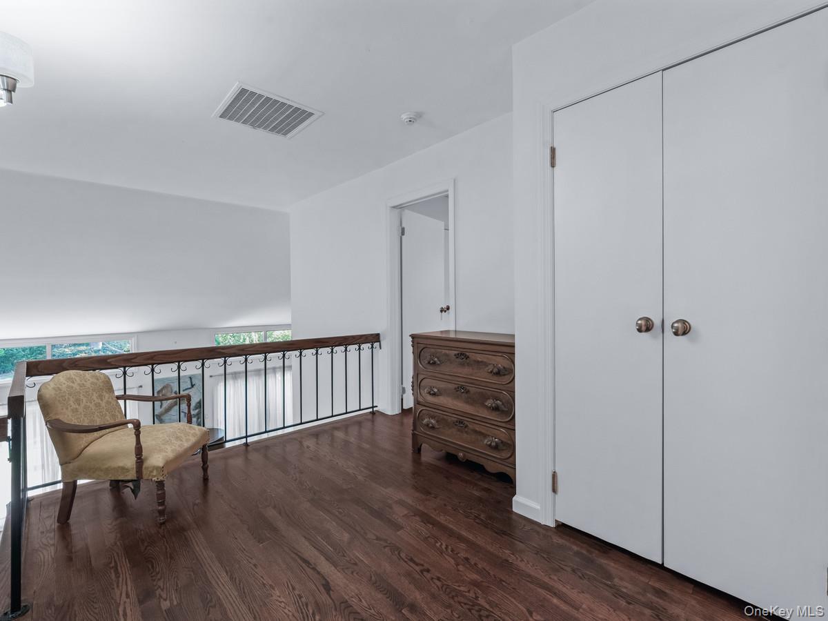 15 Fairway Circle South, Unit 15 Manhasset, NY 11030 - Photo 25 of 39 Second floor loft area, with a sitting area overlooking the first floor, featuring dark wood finished floors