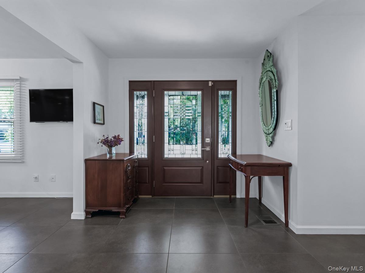 15 Fairway Circle South, Unit 15 Manhasset, NY 11030 - Photo 5 of 39 Entryway with healthy amount of natural light and dark tile patterned flooring