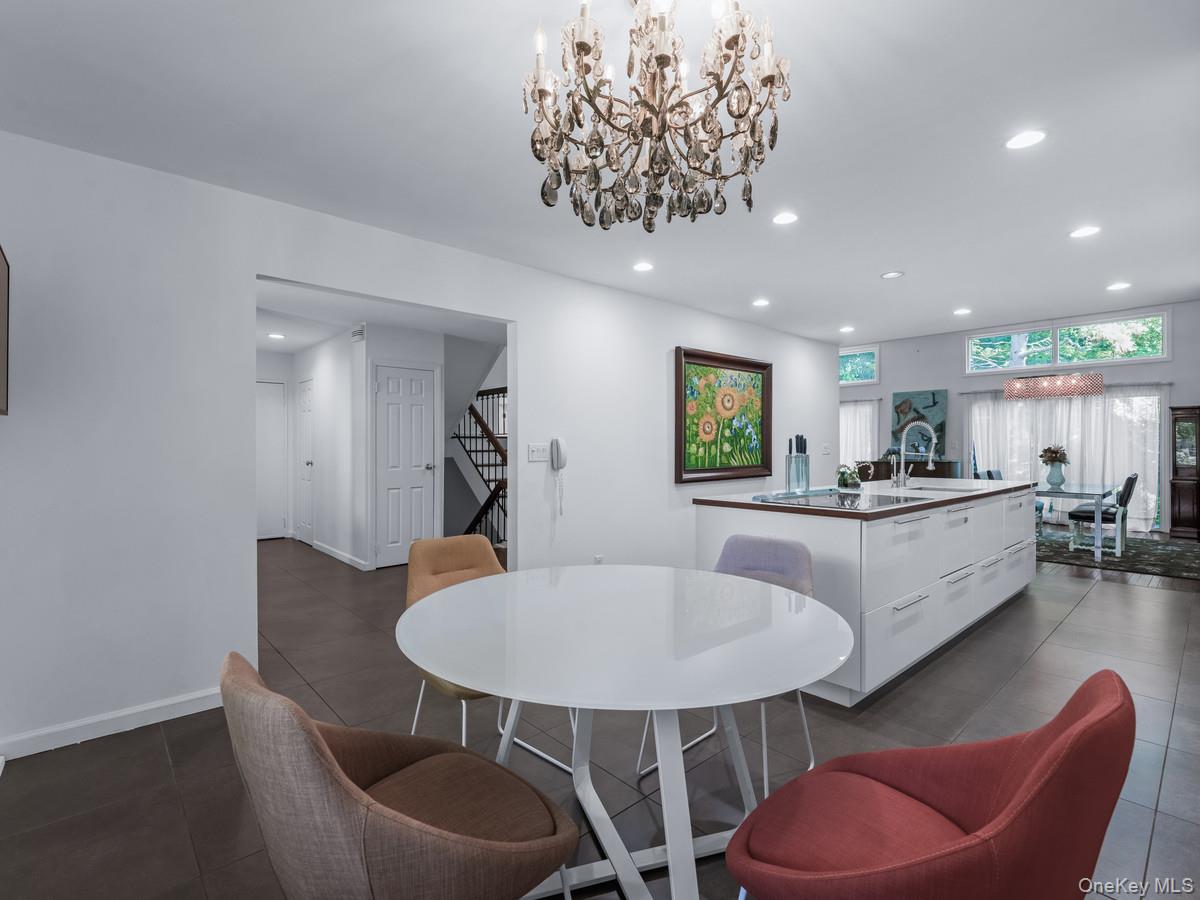 15 Fairway Circle South, Unit 15 Manhasset, NY 11030 - Photo 10 of 39 Kitchen's breakfast area featuring recessed lighting, stairway, a chandelier, and dark tile patterned flooring