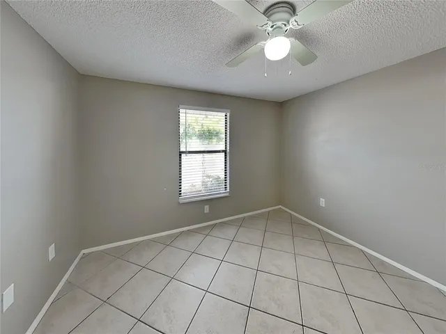 an empty room with fan and windows
