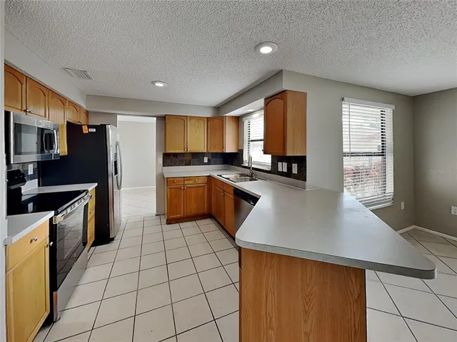 a kitchen with stainless steel appliances a refrigerator sink and microwave