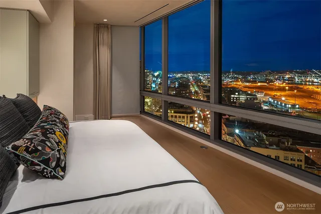 a large bed sitting in a large bedroom next to a cabinet