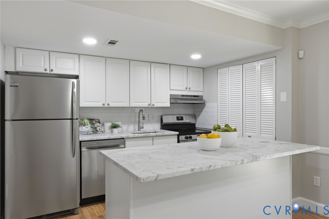 22 Ashinghurst Road, Unit 22 Henrico, VA 23238 - Photo 9 of 25 a kitchen with a sink a refrigerator and wooden cabinets