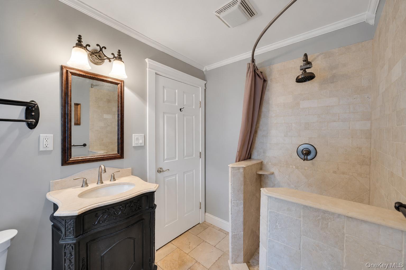 19 Joan Road Bay Shore, NY 11706 - Photo 19 of 50 Walk-in shower with tiled walls and floor, featuring a dark bronze rainfall showerhead and control