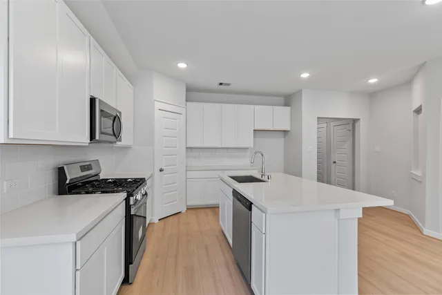 a kitchen that has a sink a stove and a refrigerator