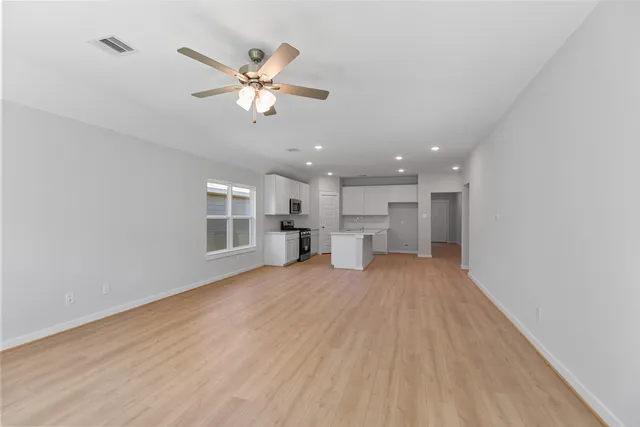 a view of a livingroom with a ceiling fan and window