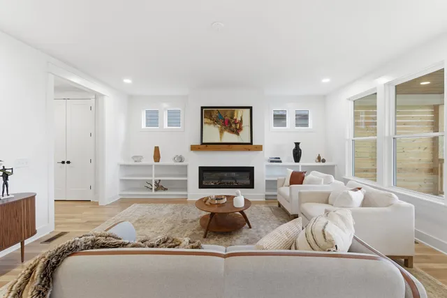 a living room with furniture a fireplace and a potted plant