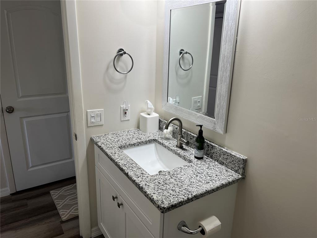 2254 Norwegian Drive, Unit 6 Clearwater, FL 33763 - Photo 30 of 56 a bathroom with a granite countertop sink and a mirror