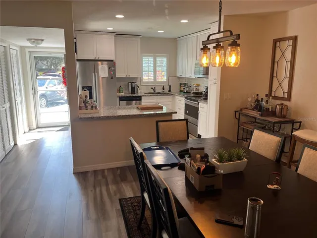 a kitchen with a table chairs refrigerator and microwave