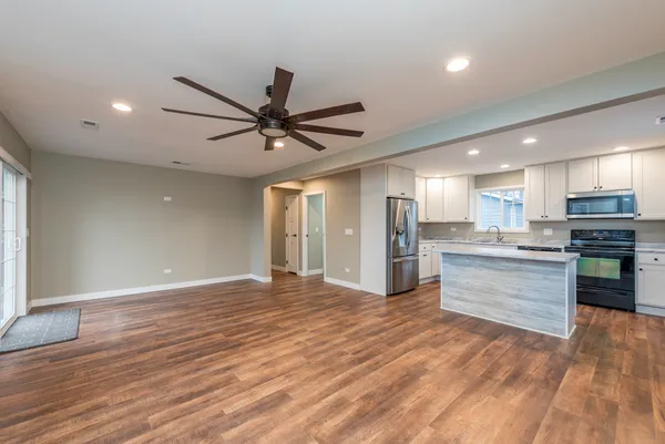 a view of kitchen with granite countertop cabinets and refrigerator