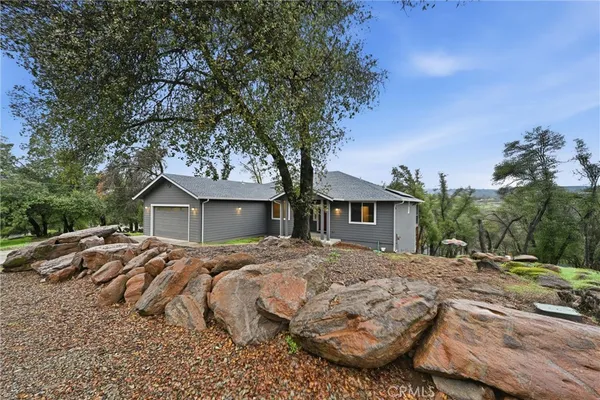 a view of a house with a tree in front of it