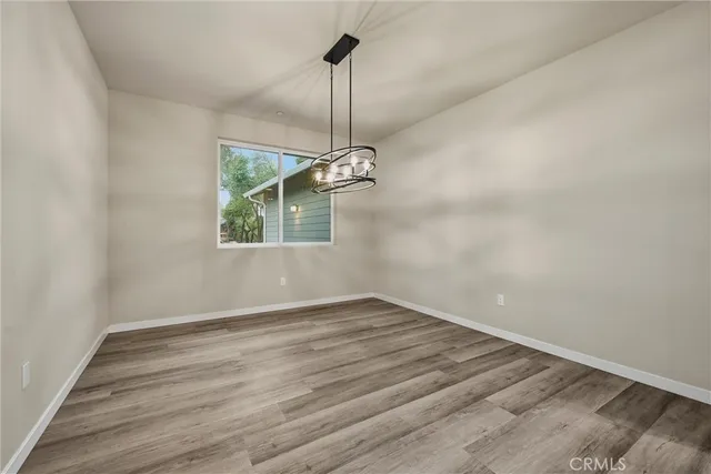 a view of a room with wooden floor ceiling fan and windows