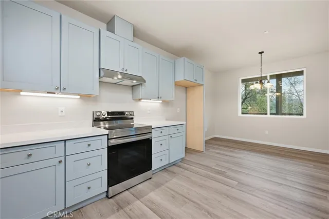 a kitchen with appliances cabinets and a wooden floor