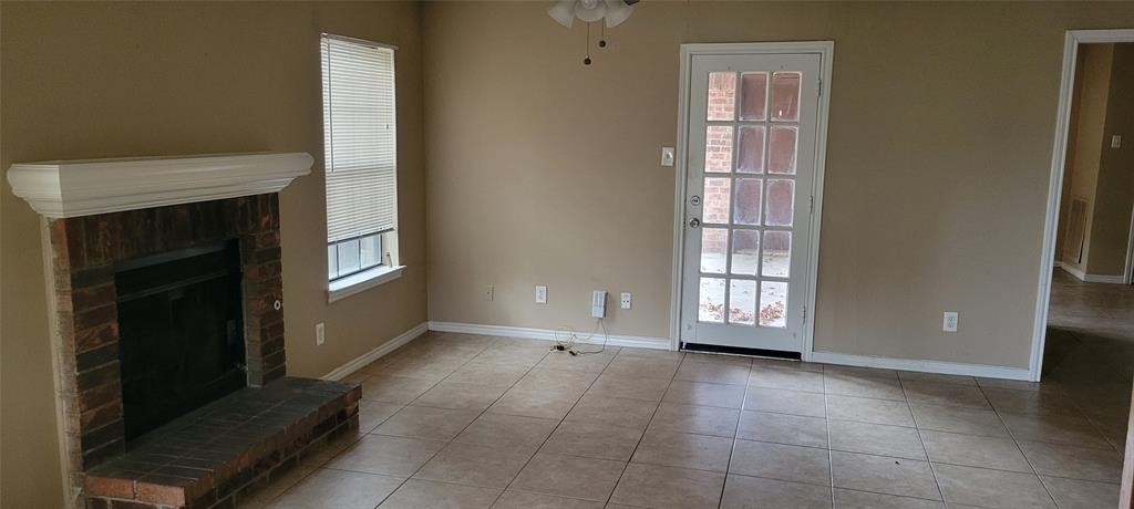 3031 Modella Avenue Dallas, TX 75229 - Photo 2 of 15 Unfurnished living room with a fireplace, ceiling fan, and light tile patterned flooring