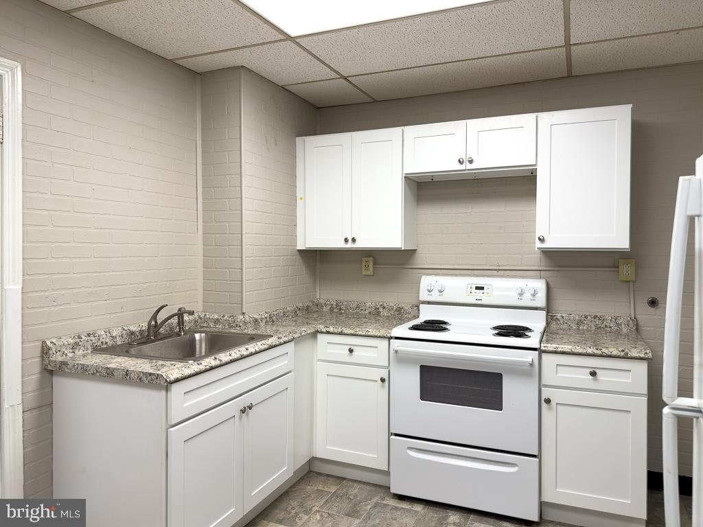 658 Walnut Street, Unit 1 Pottstown, PA 19464 - Photo 3 of 19 a white kitchen with granite countertop white cabinets and white appliances