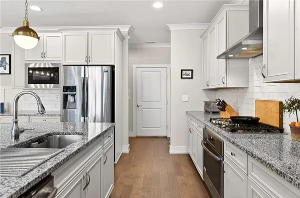 a kitchen with stainless steel appliances granite countertop a sink stove and refrigerator