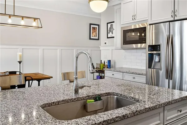 a kitchen with stainless steel appliances granite countertop a sink a microwave refrigerator and a stove