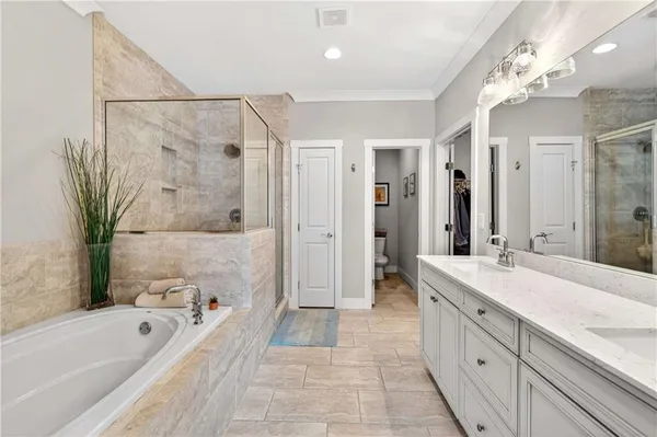 a spacious bathroom with a tub sink a mirror a shower and vanity
