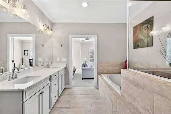a spacious bathroom with a granite countertop sink mirror and bathtub