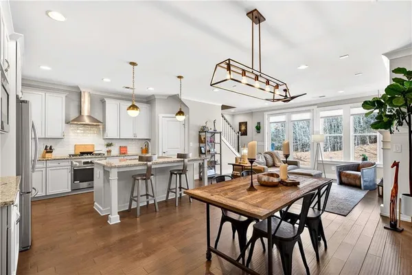 a view of a dining room and livingroom with furniture wooden floor a chandelier