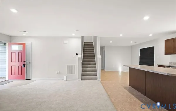 an empty room with a hallway and stairs