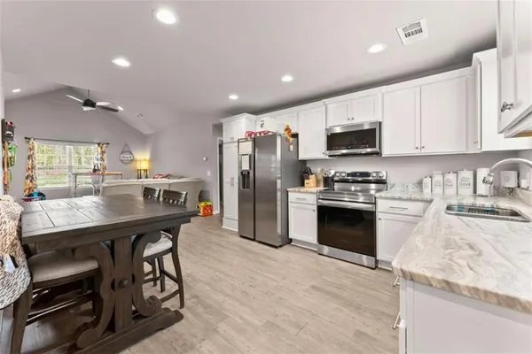a kitchen with stainless steel appliances granite countertop a stove refrigerator sink and cabinets