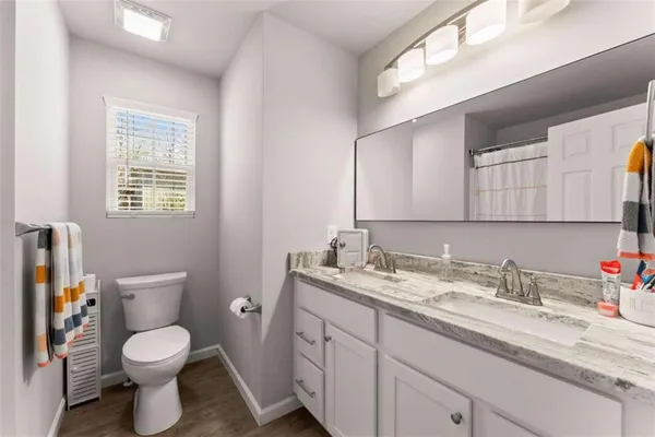 a bathroom with a granite countertop toilet sink and a mirror