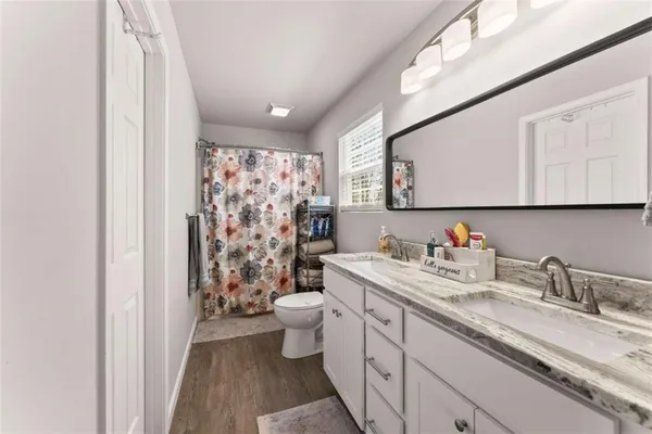 a bathroom with a granite countertop sink mirror vanity and toilet