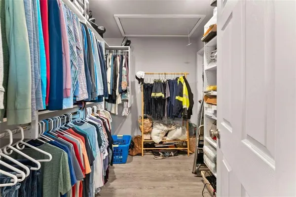 a view of walk in closet with clothes and shoes