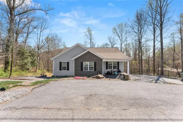 a view of a house with a yard and large tree