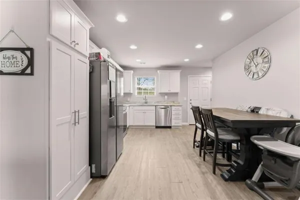 a kitchen with stainless steel appliances a refrigerator and a dining table