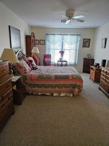 a spacious bedroom with a bed couch and window