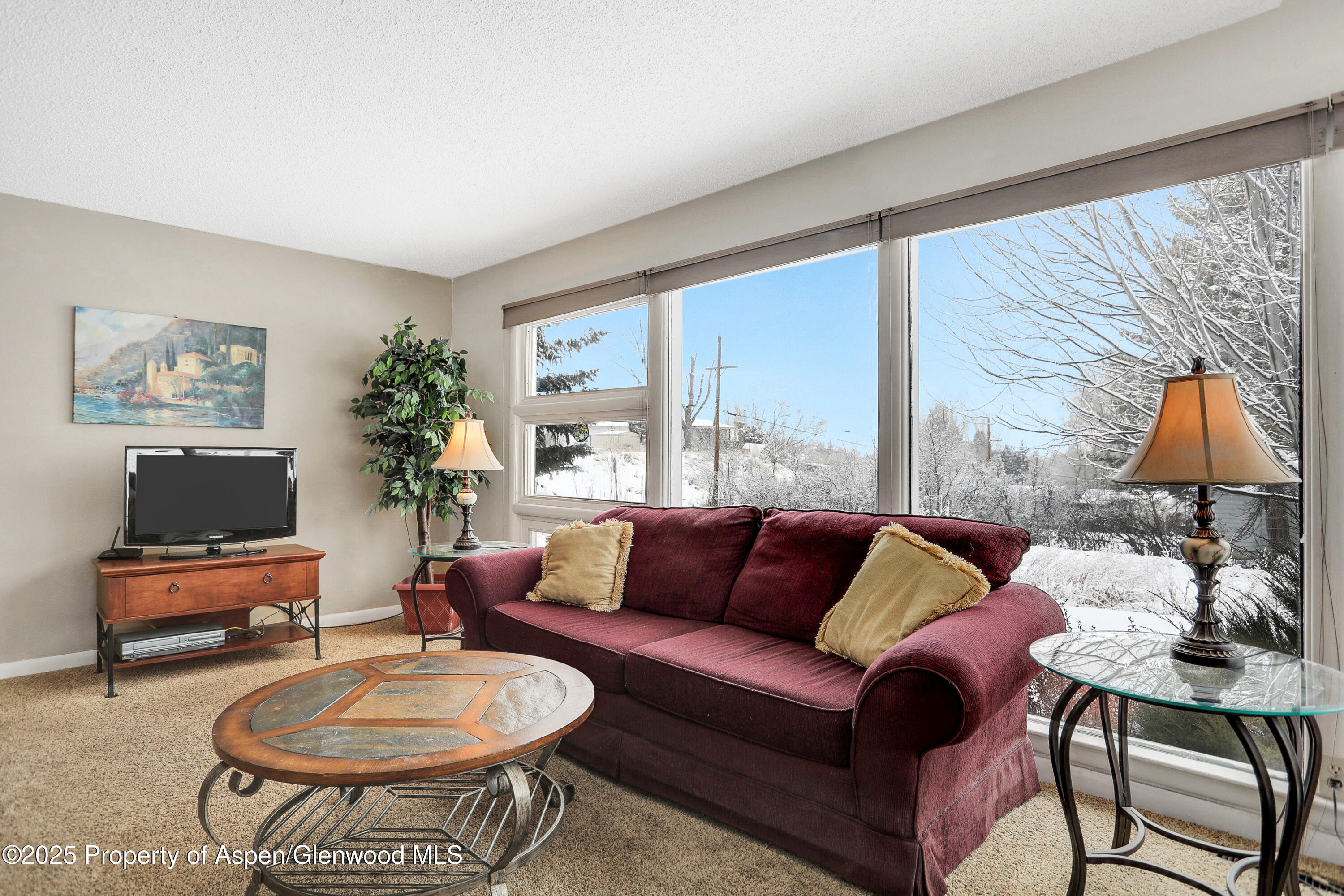 901 Pershing Street Craig, CO 81625 - Photo 3 of 37 a living room with furniture a flat screen tv and a large window