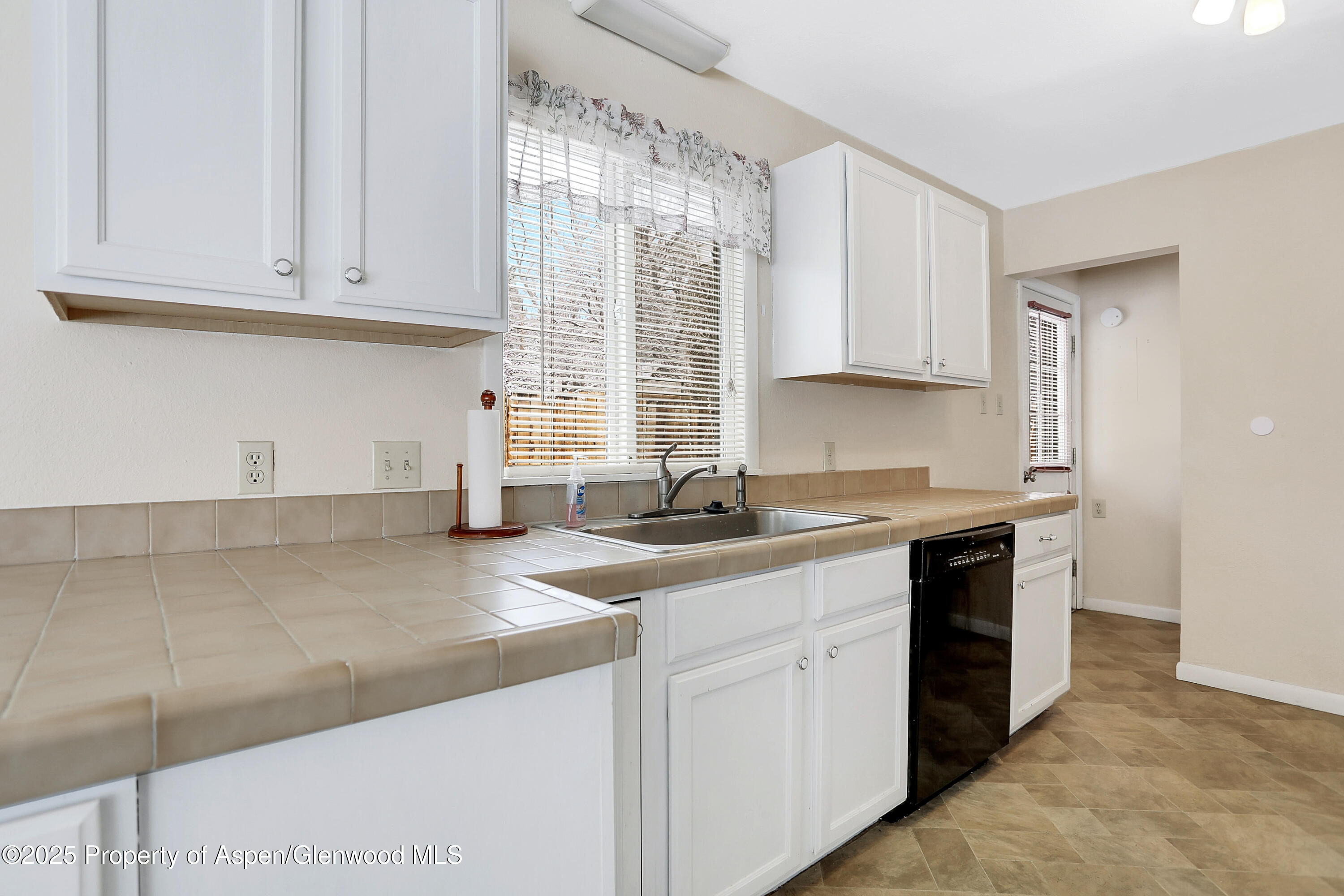901 Pershing Street Craig, CO 81625 - Photo 10 of 37 a kitchen with stainless steel appliances granite countertop a sink a stove and a white cabinets