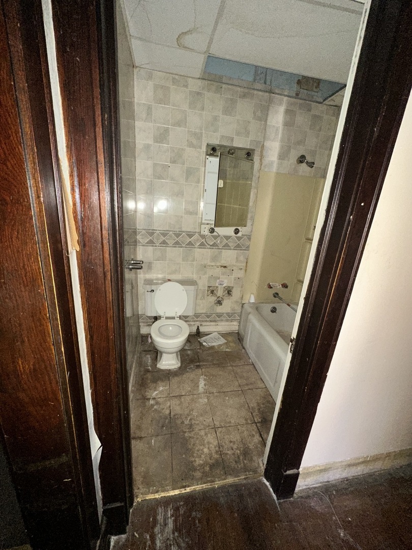 7425 South Harvard Avenue Chicago, IL 60621 - Photo 9 of 31 a bathroom with a sink and a mirror