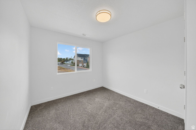 295 Spruce Way Santaquin, UT 84655 - Photo 19 of 32 Bright room featuring a double-pane window, neutral-toned walls, gray carpeting, and a flush mount ceiling light