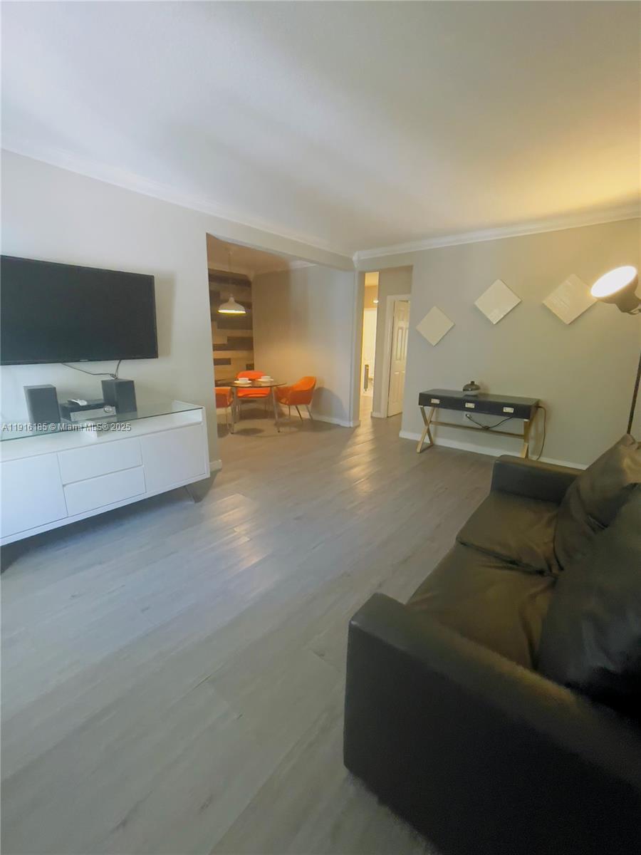7710 Harding Avenue, Unit 403 Miami Beach, FL 33141 - Photo 3 of 7 a living room with furniture and a flat screen tv
