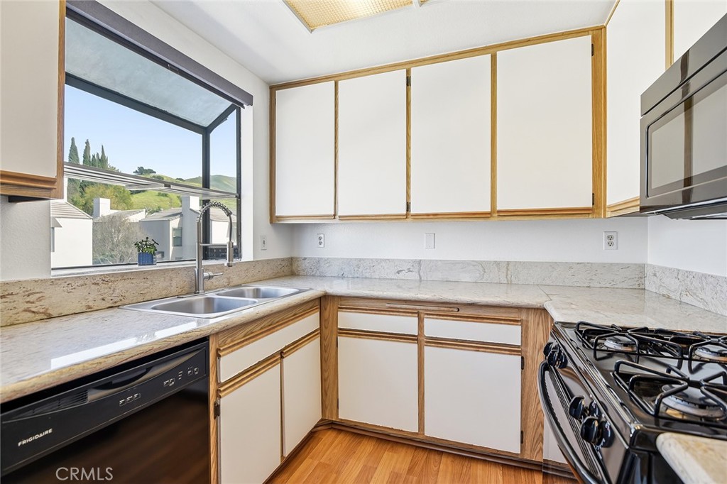 4265 Las Virgenes Road, Unit 2 Calabasas, CA 91302 - Photo 11 of 26 a kitchen with a sink stove and cabinets