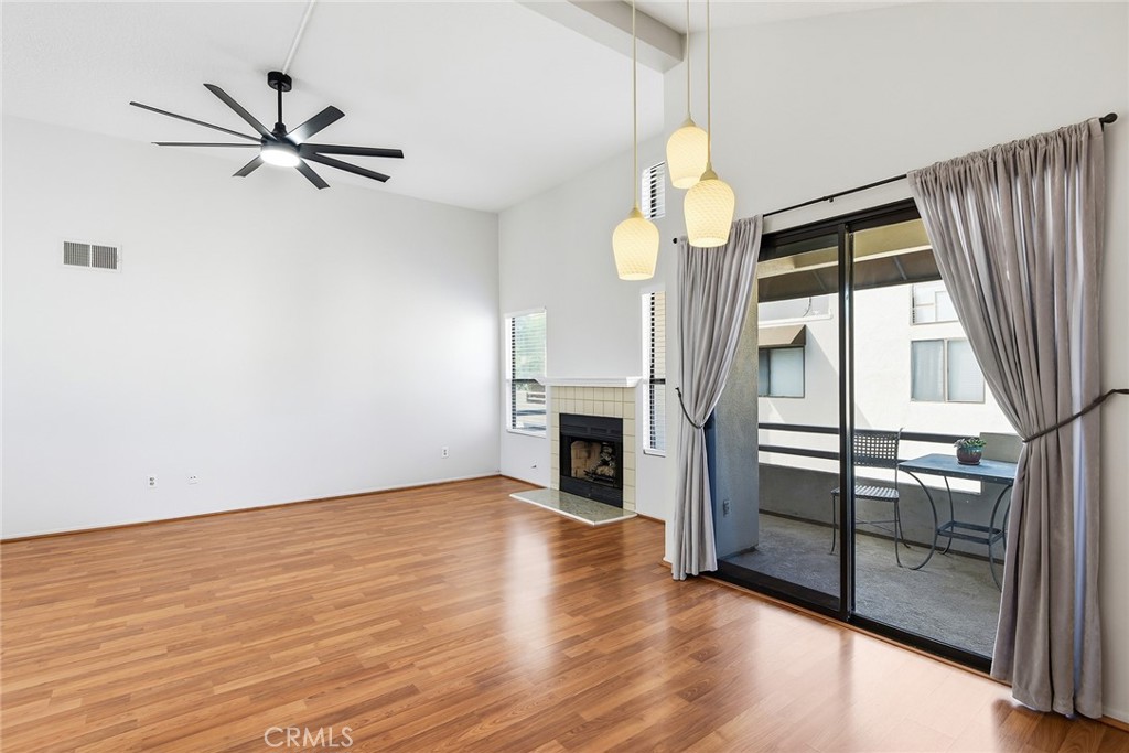 4265 Las Virgenes Road, Unit 2 Calabasas, CA 91302 - Photo 12 of 26 an empty room with wooden floor fireplace and windows