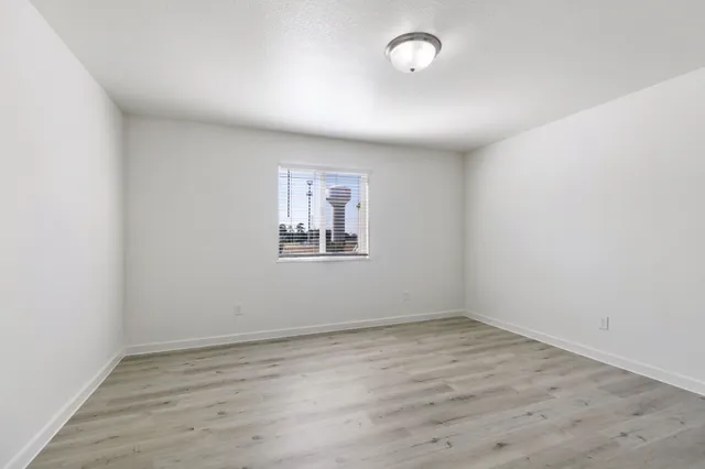 a view of an empty room with wooden floor