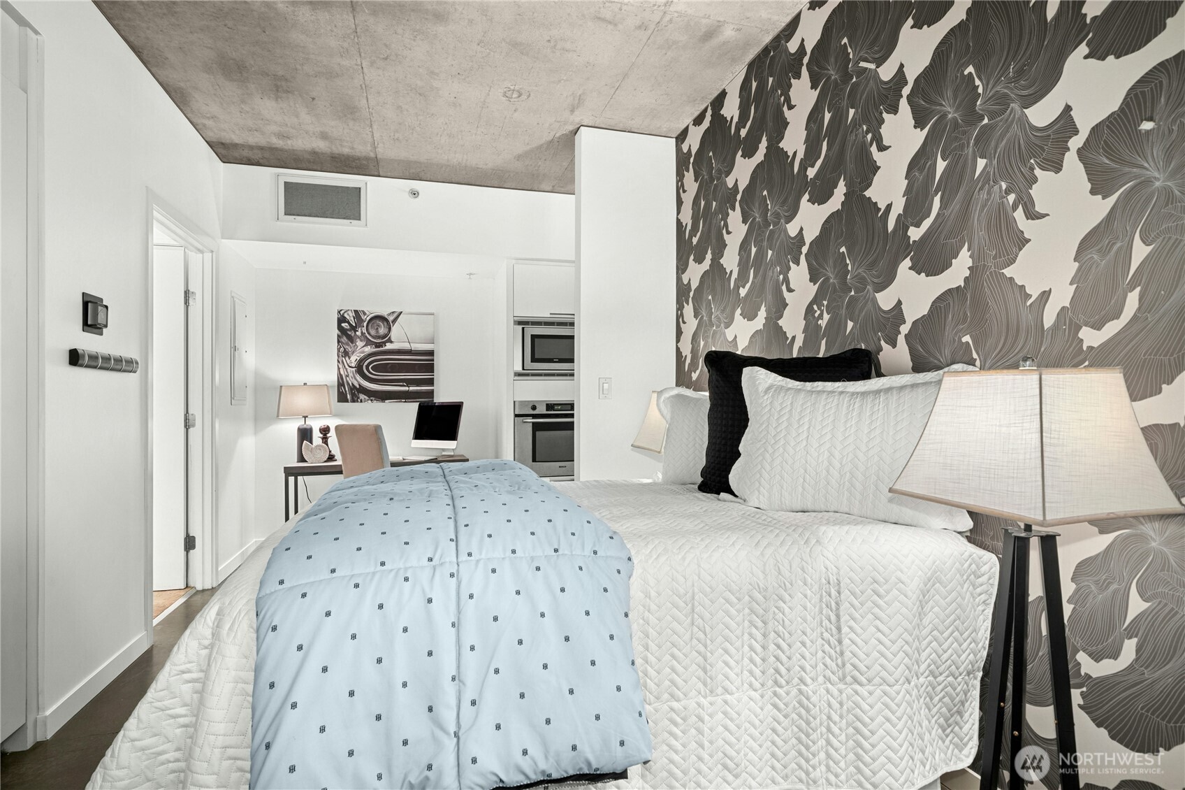 501 Roy Street, Unit F239 Seattle, WA 98109 - Photo 13 of 27 a large bedroom with a bed and a lamp on dresser